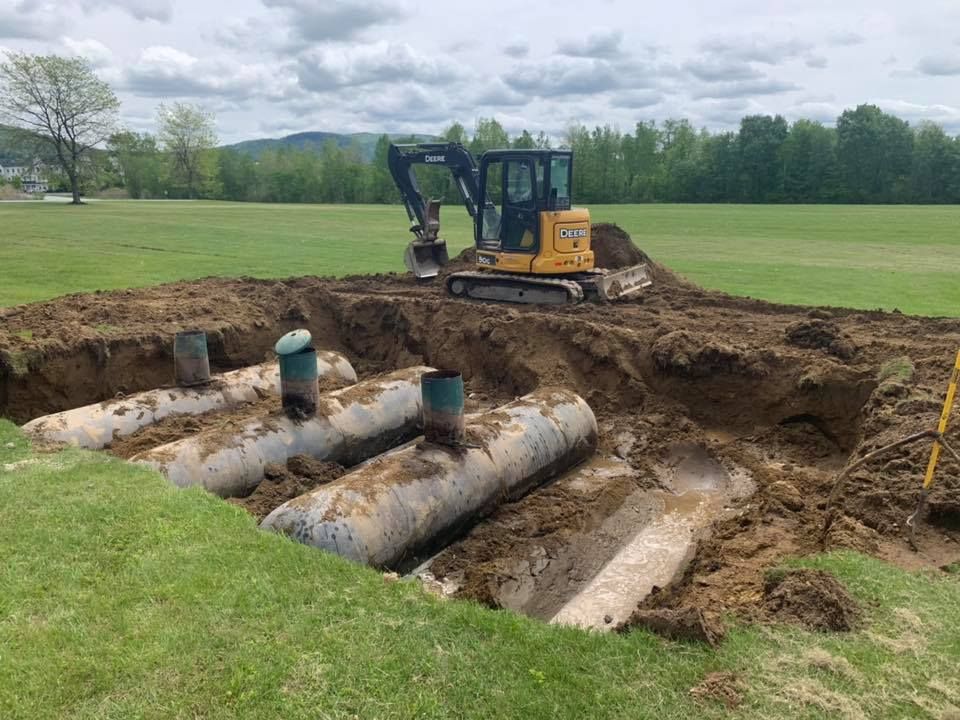 A bulldozer is digging a hole in the ground in a field.