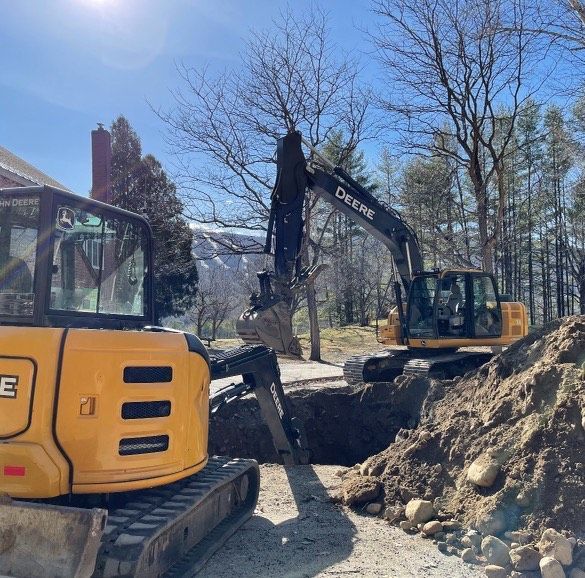 A deere excavator is digging a hole in the ground