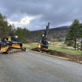 A bulldozer is driving down a road next to a golf course.