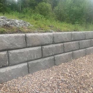 A brick wall is sitting on top of a pile of gravel.