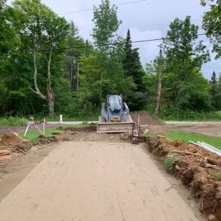 A bulldozer is driving down a dirt road.