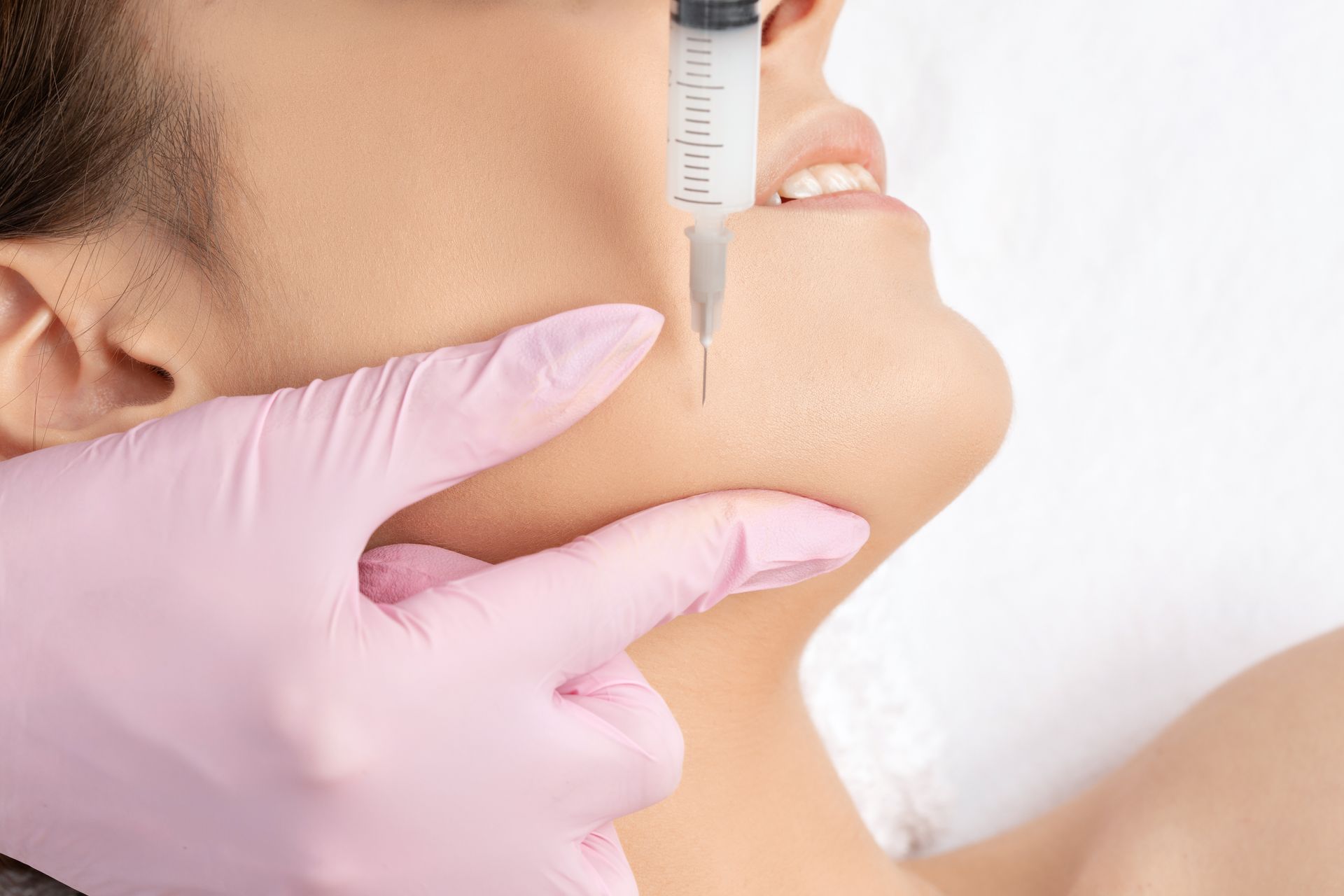 A woman is getting a botox injection in her face.