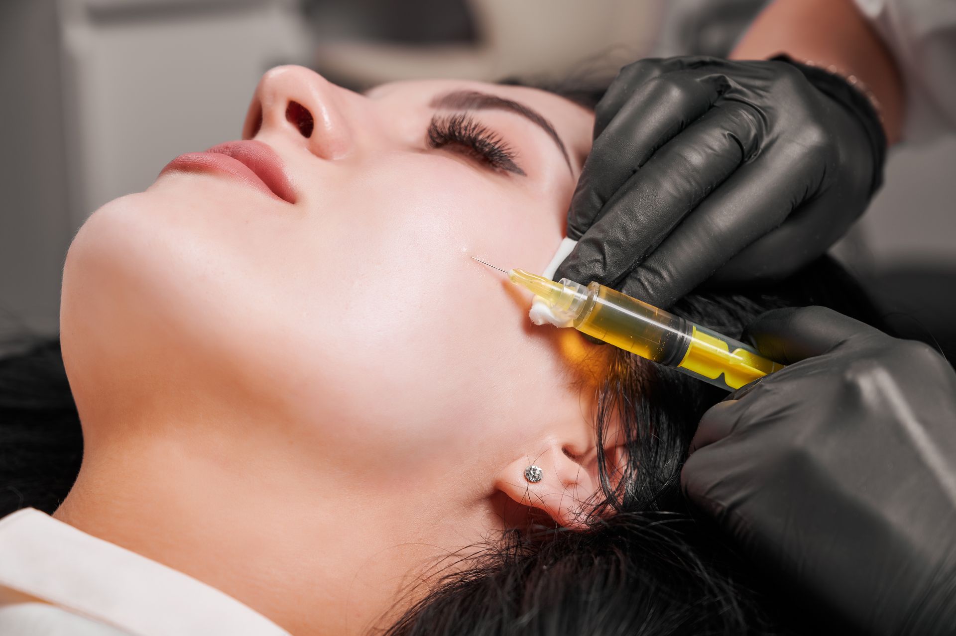 a woman is getting a botox injection in her face .