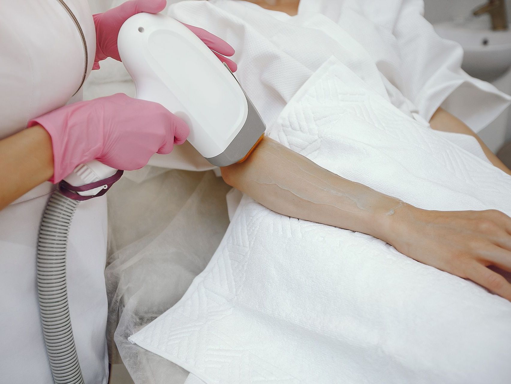 a woman is getting a laser hair removal treatment on her arm .