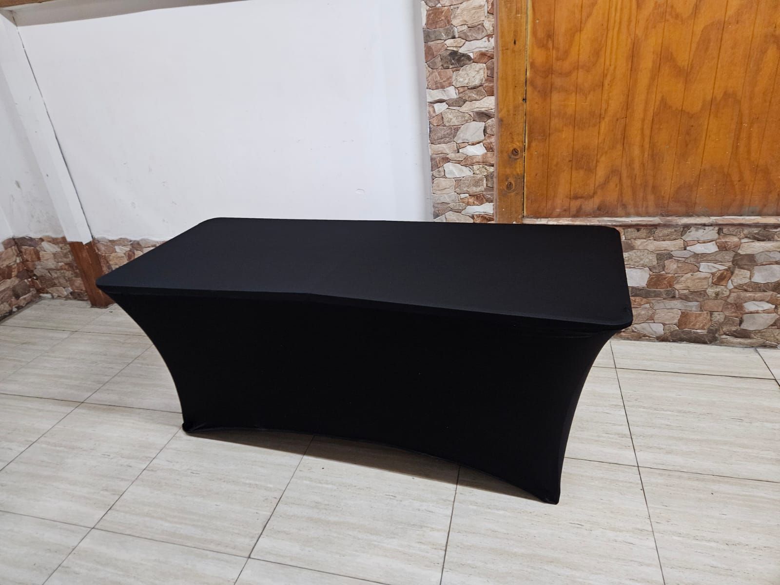 Cubierta de mesa de spandex negro sobre una mesa rectangular, en el interior.