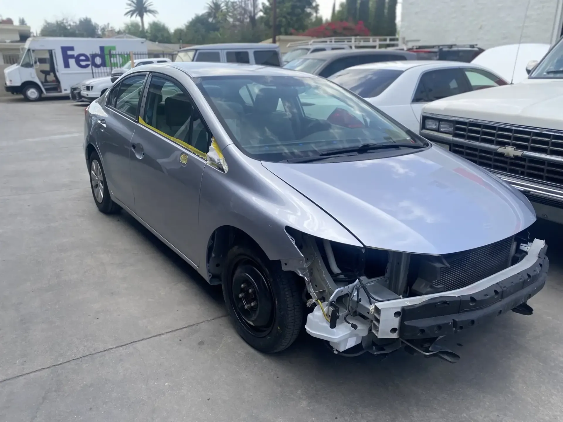 A damaged car is parked in a parking | Northridge Bodyworks