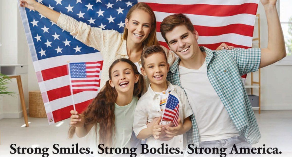 Four smiling youths holding U.S. flags in Robert A. Lantzy, DMD, LLC Complete Health Dentistry blog
