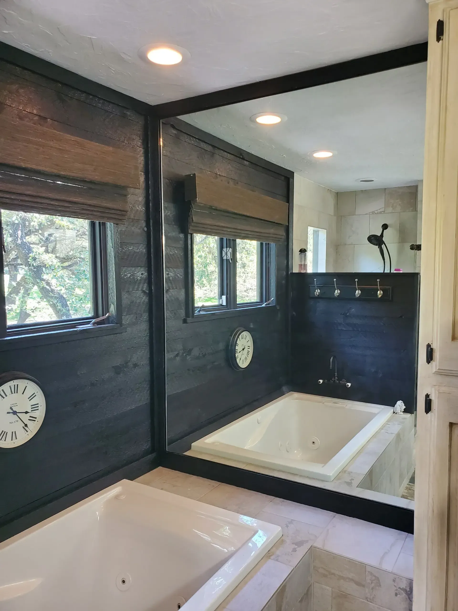 A bathroom with two tubs and a large mirror.
