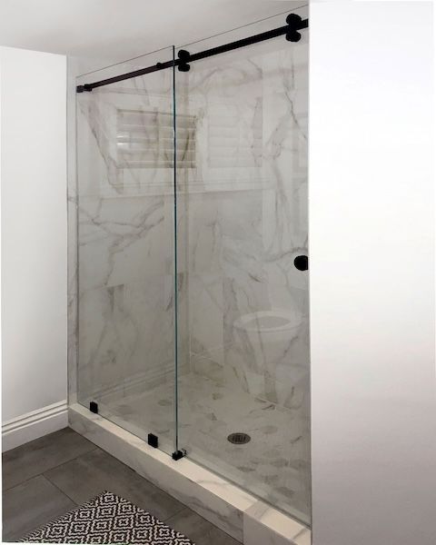 A bathroom with a sliding glass shower door