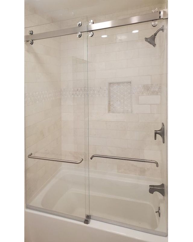 A bathroom with a sliding glass shower door
