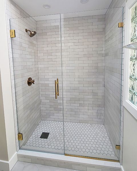 A bathroom with a shower door and a sink.