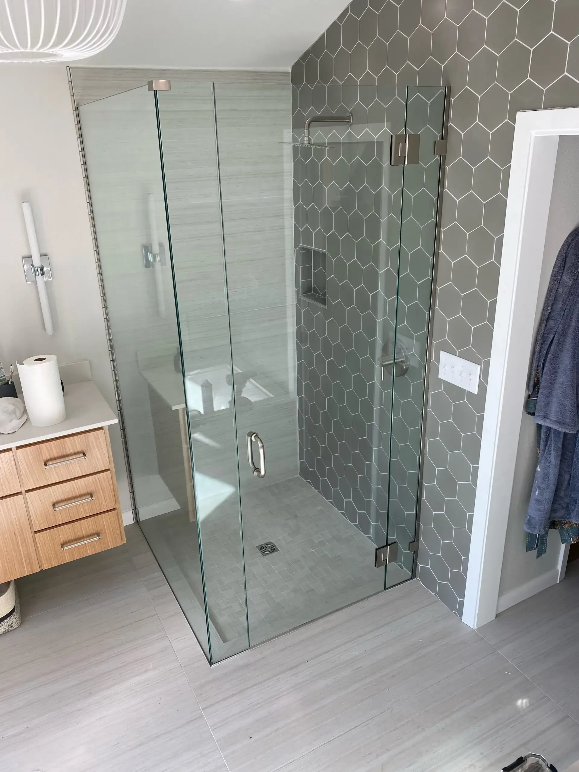 A bathroom with a walk in shower and a sink.