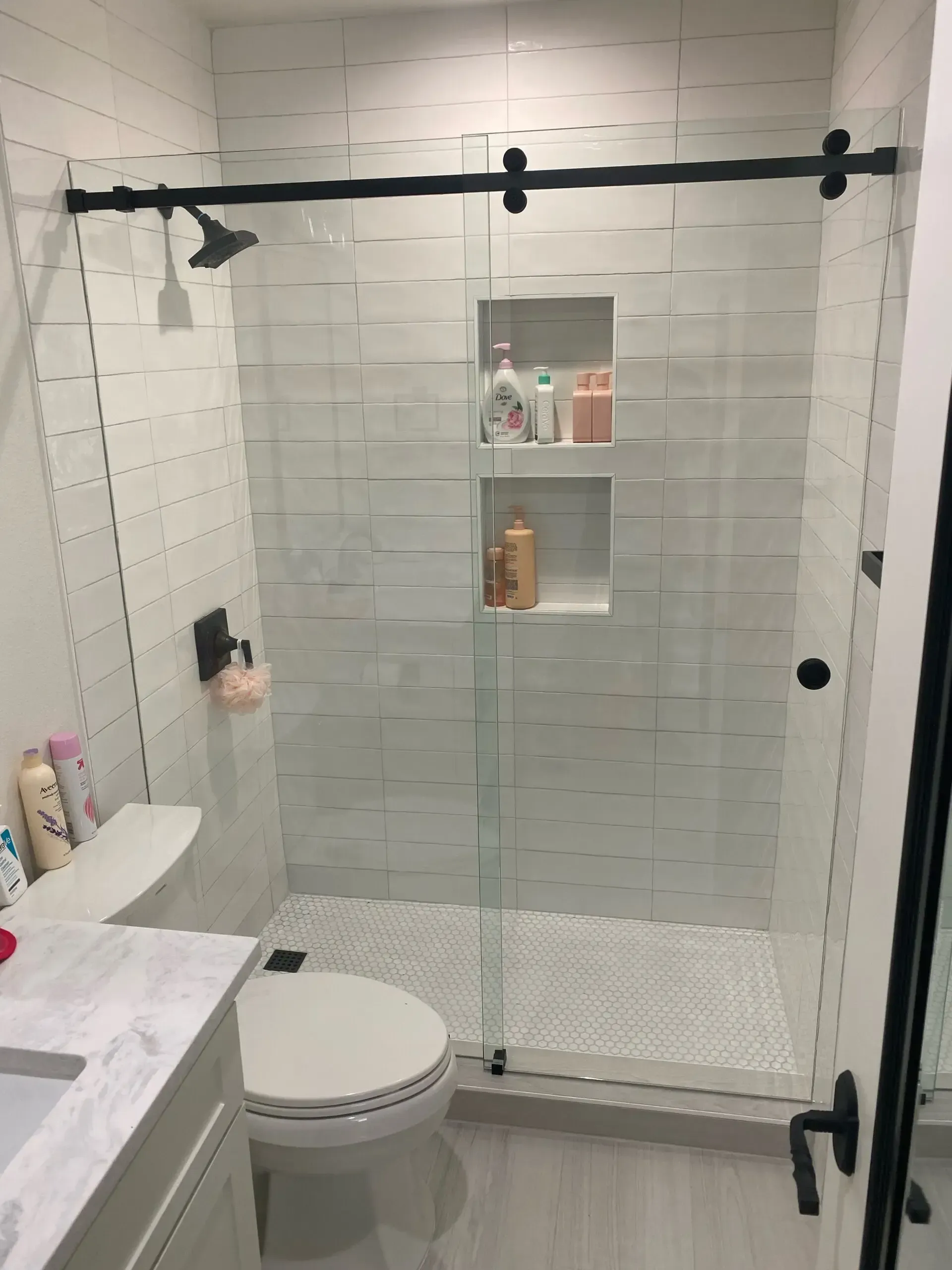 A bathroom with a toilet , sink , shower and sliding glass door.