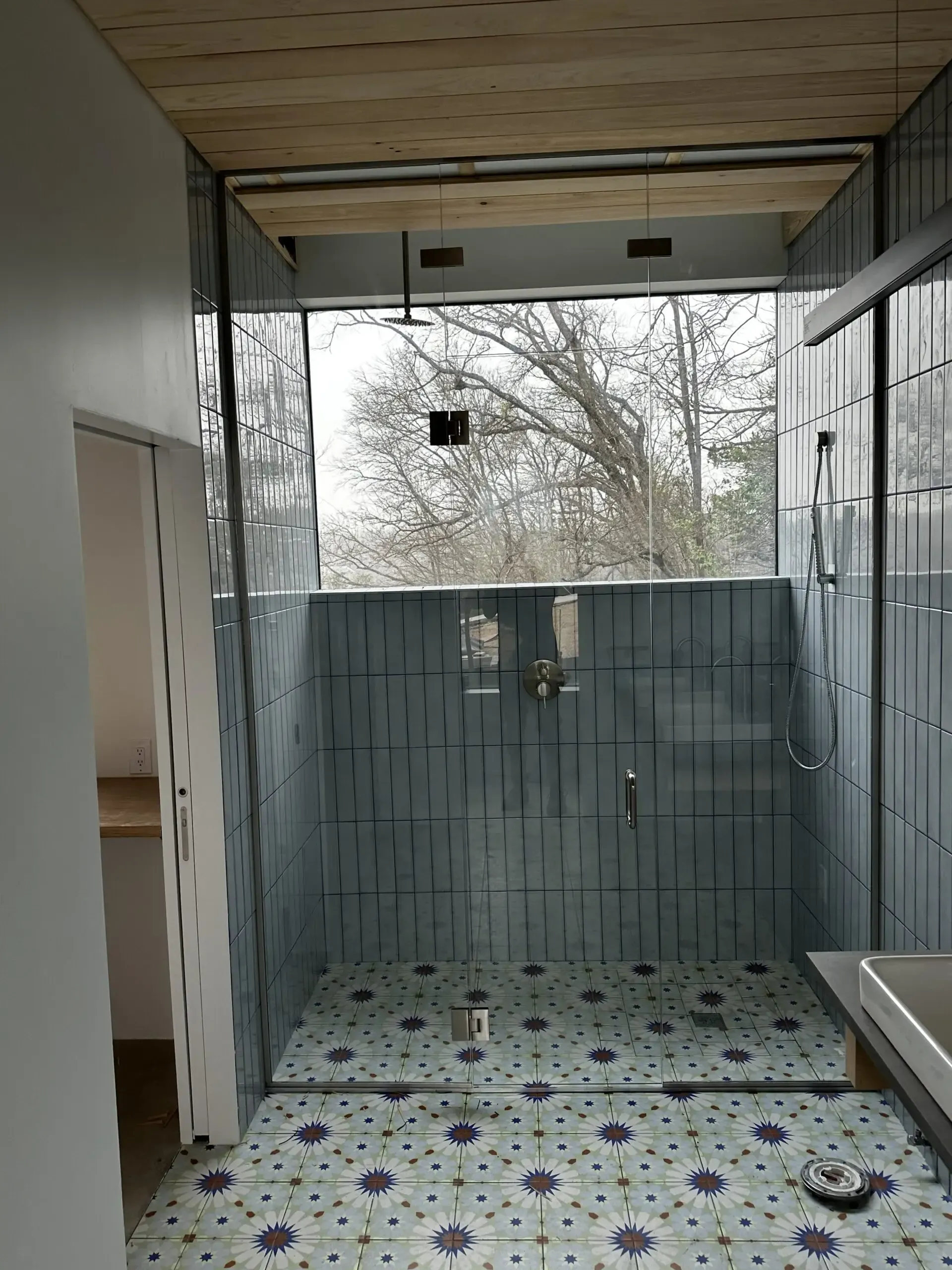A bathroom with a walk in shower and a window