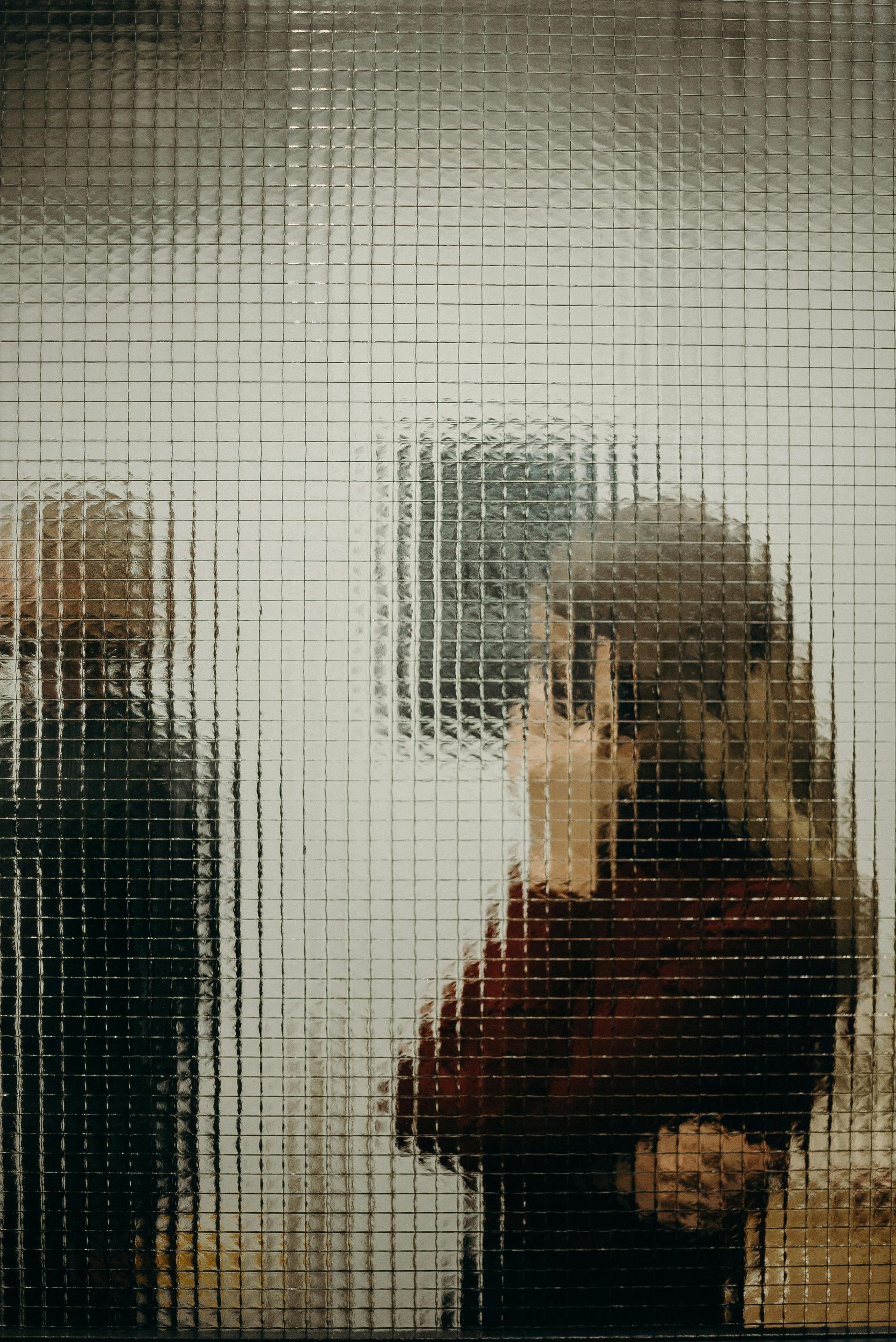 A person behind a textured glass door
