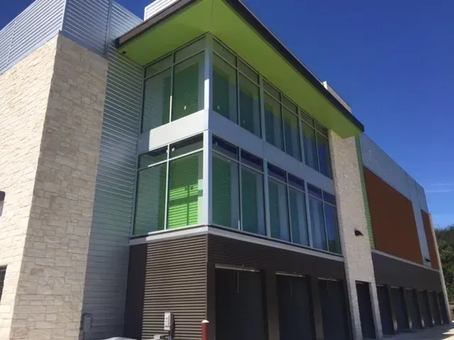 A large building with lots of windows and a green roof