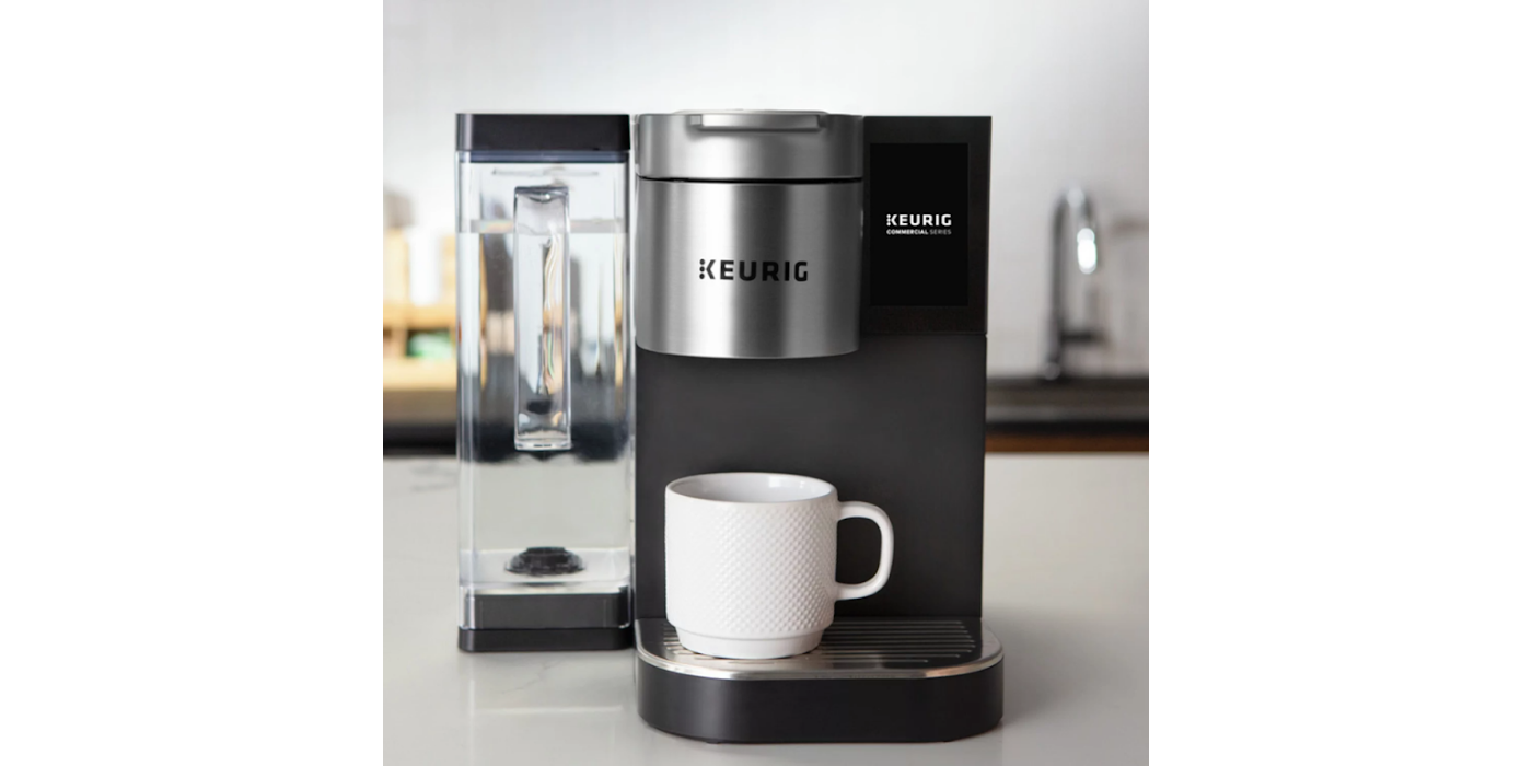 Keurig coffee maker with a white mug on a countertop.