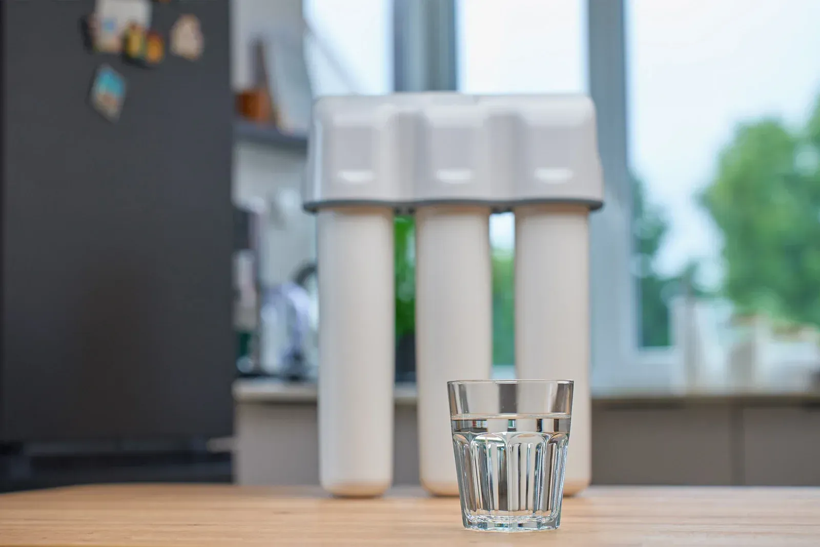 A man wearing a hard hat and goggles is standing in a room.