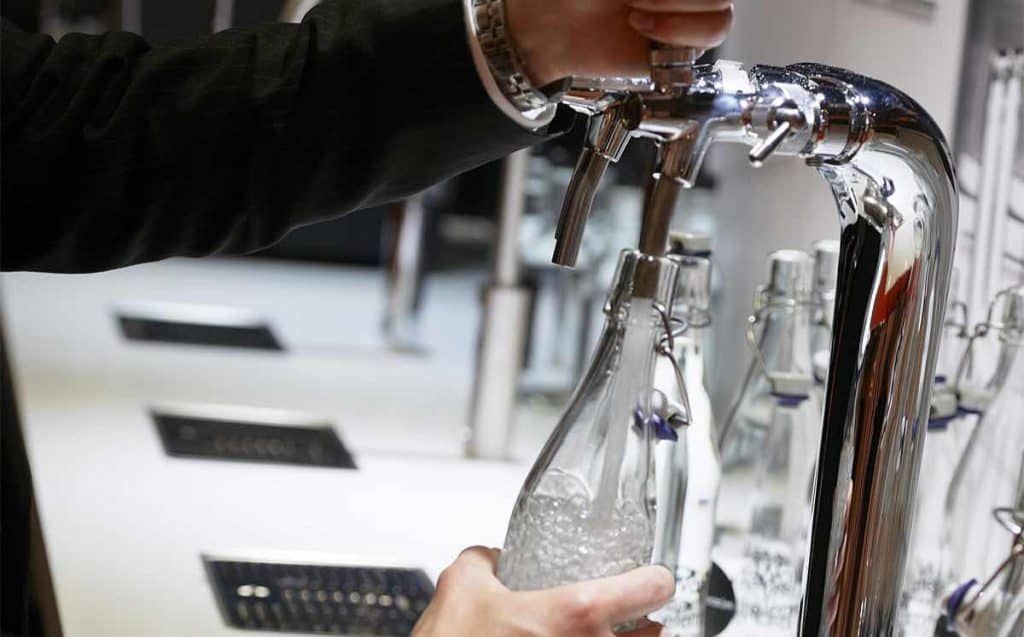 A man wearing a hard hat and goggles is standing in a room.