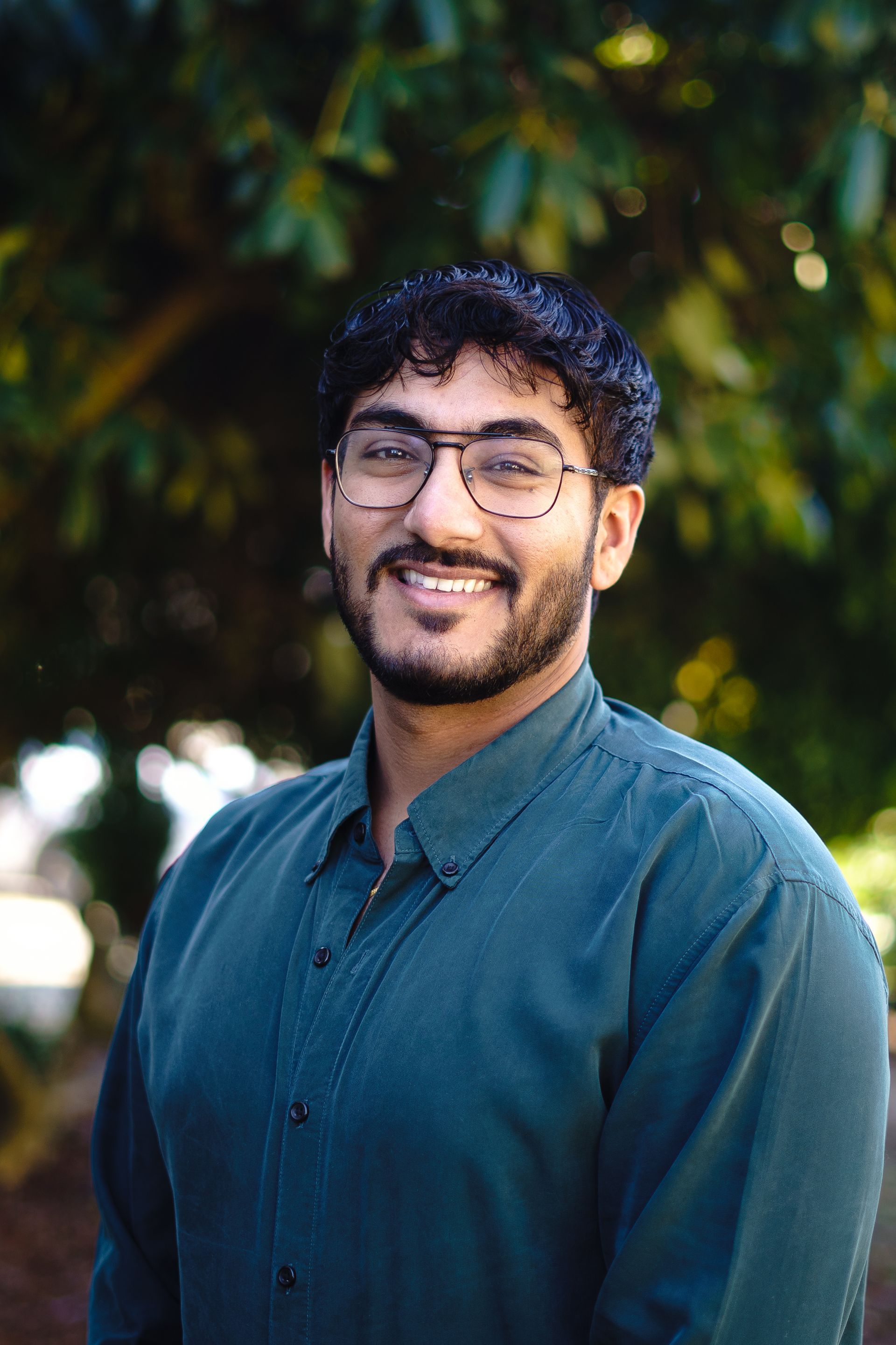A man with a beard and glasses is smiling for the camera.