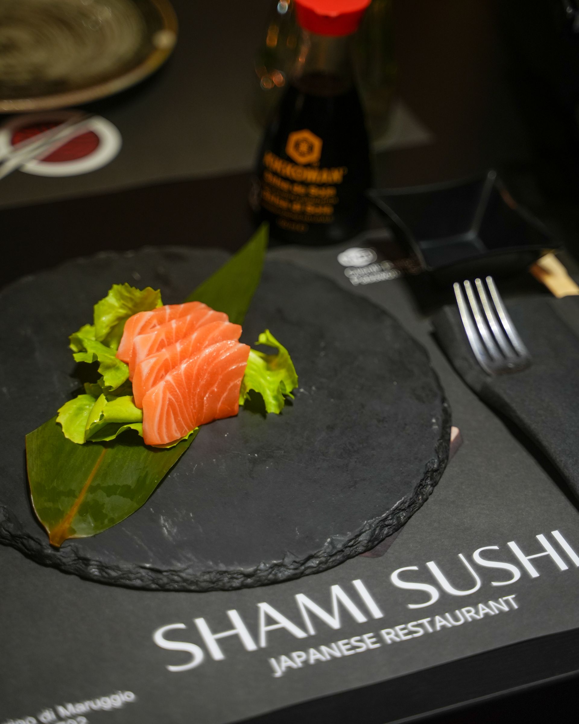 Involtini di sushi, primo piano con avocado, tonno piccante e uova d'arancia su un piatto bianco.