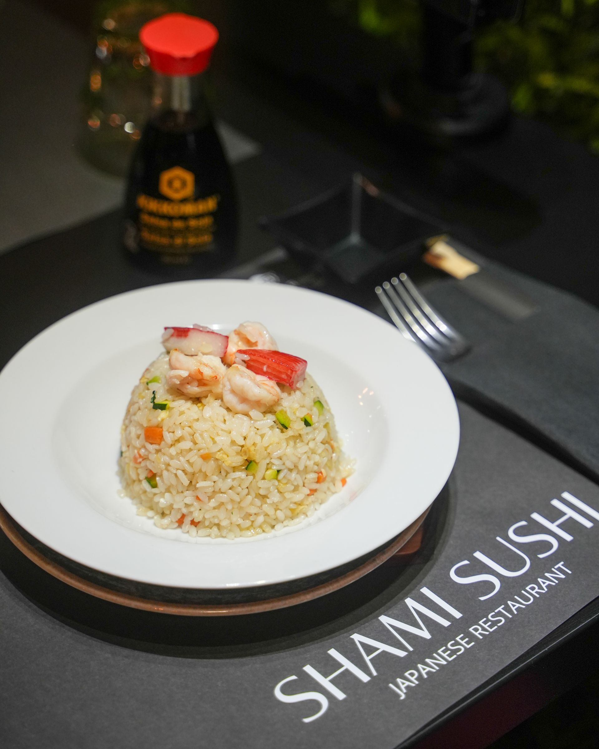 Piatti di involtini di sushi con vari condimenti e guarnizioni, disposti su un tavolo.