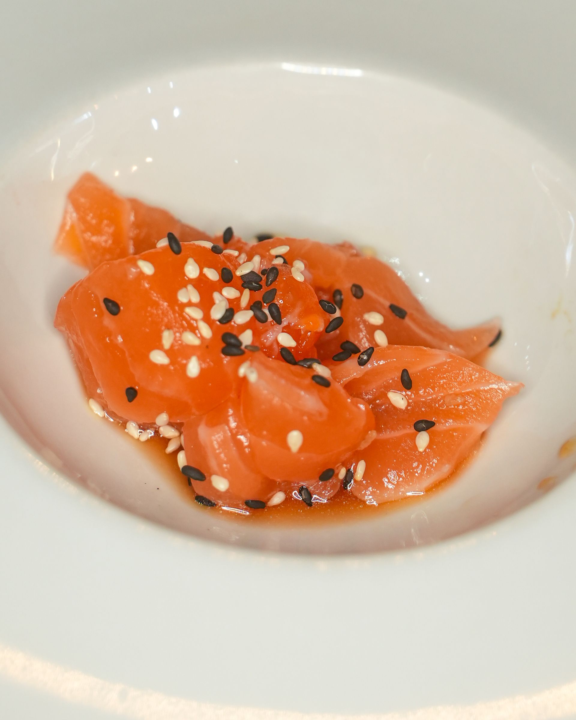 Disposizione di sushi su vassoi di ardesia nera; include nigiri, maki roll e contorni.