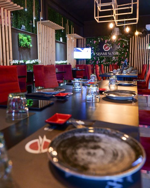 Apparecchiatura del tavolo del ristorante con lampada di cristallo, bacche rosse e posate. Atmosfera scura.