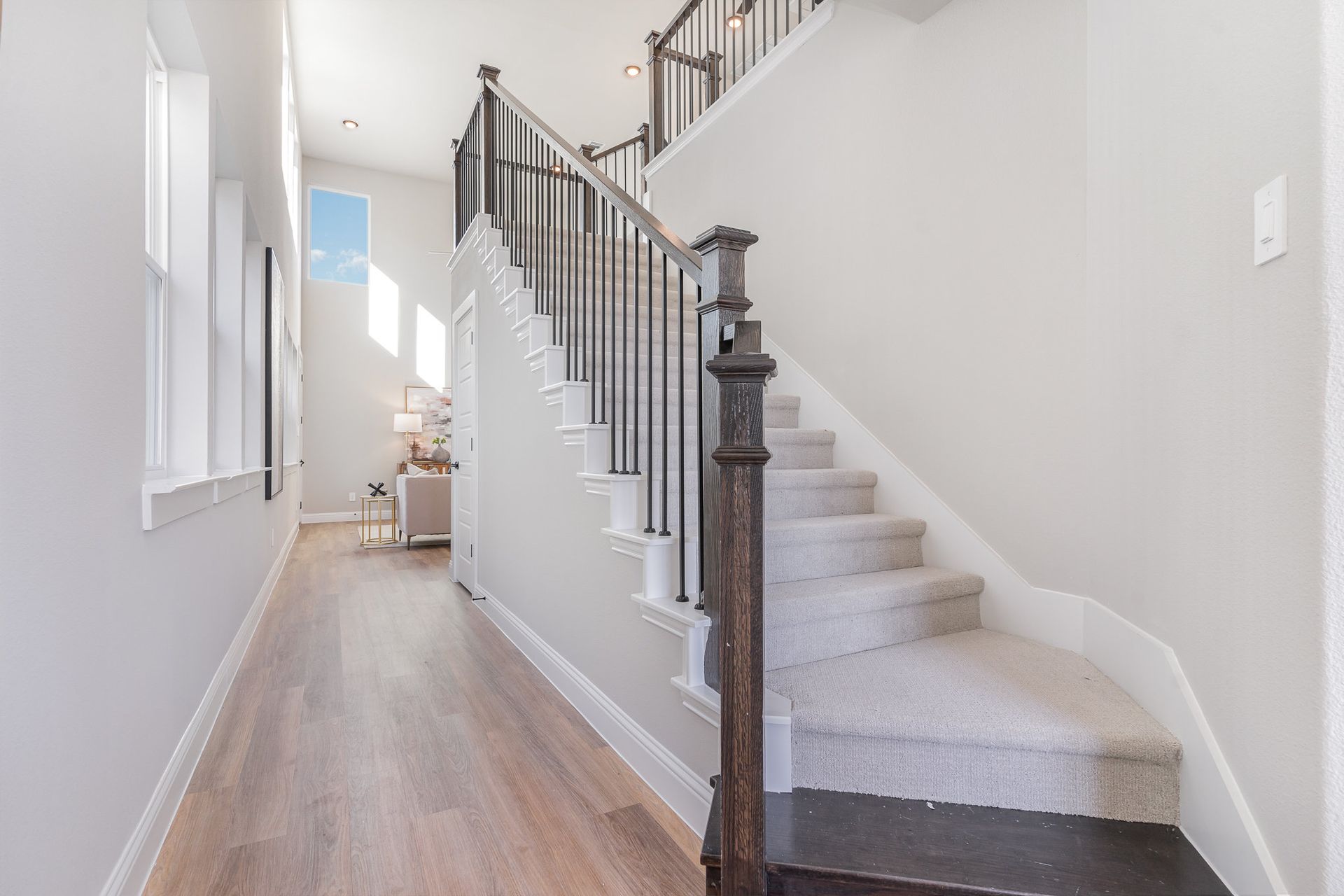 A hallway with stairs leading up to the second floor of a house.