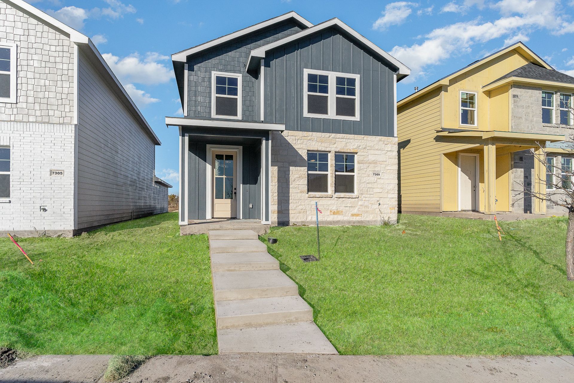A row of houses are sitting next to each other on a lush green lawn.