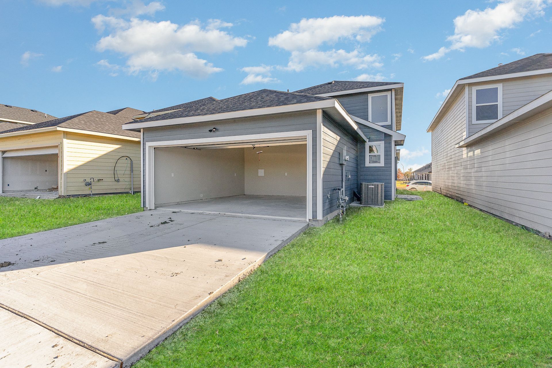 A house with a garage and a driveway in front of it.