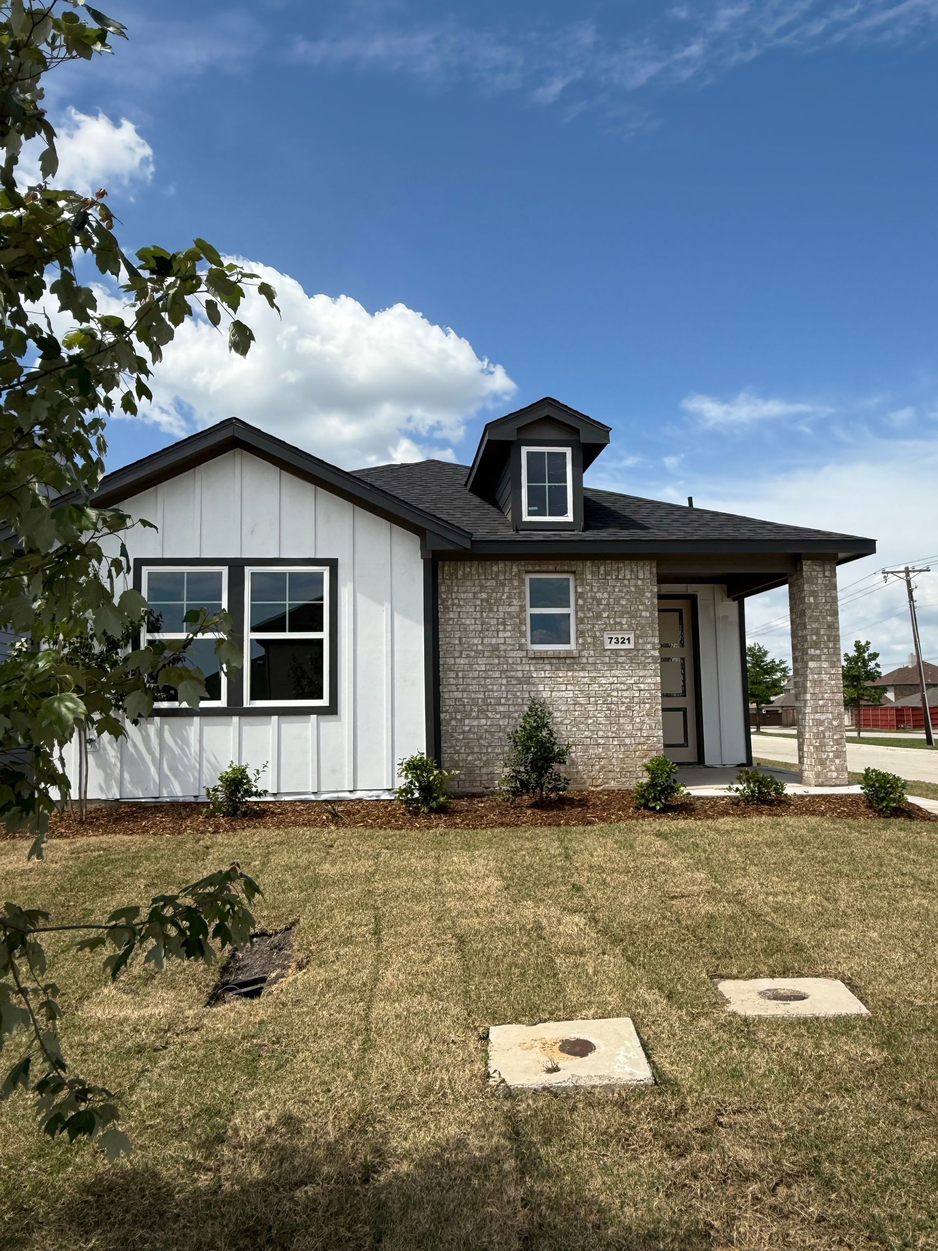 An artist 's impression of a house with a black roof and white siding.