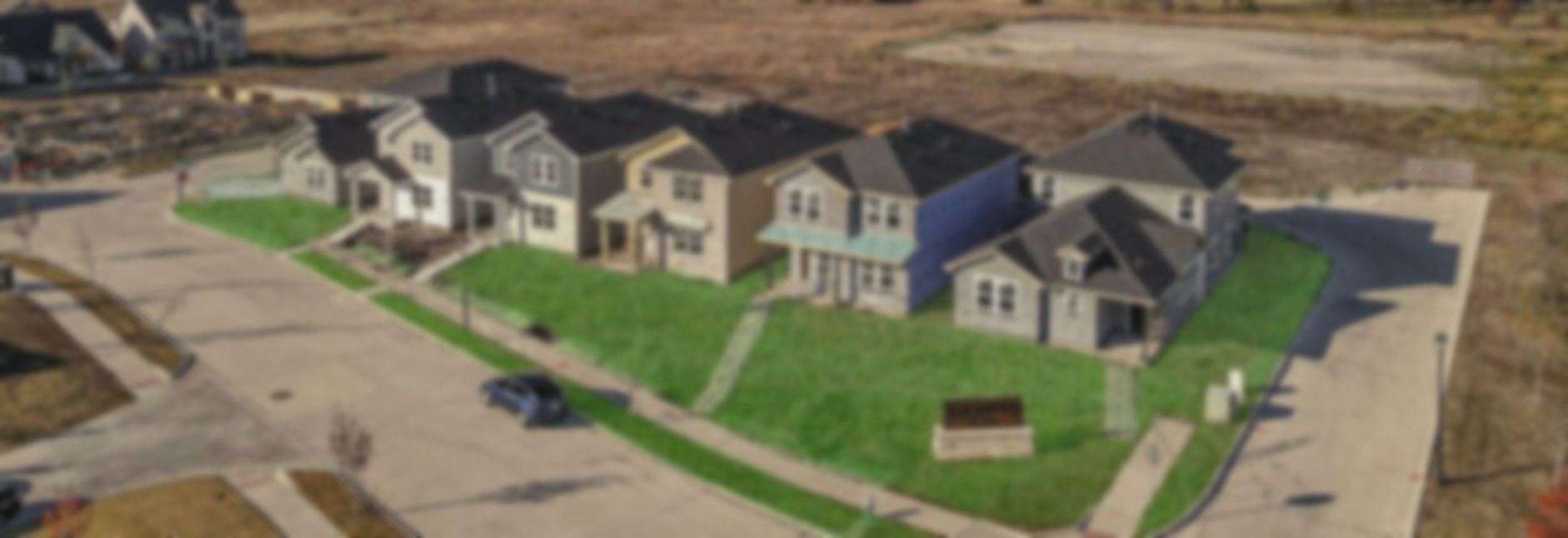 An aerial view of a residential area with a river in the background.