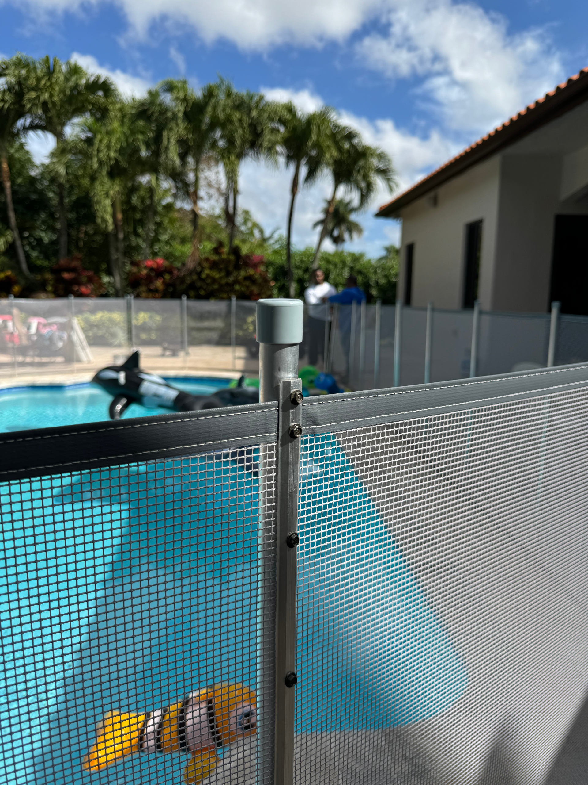 a fence surrounds a swimming pool with a fish in it