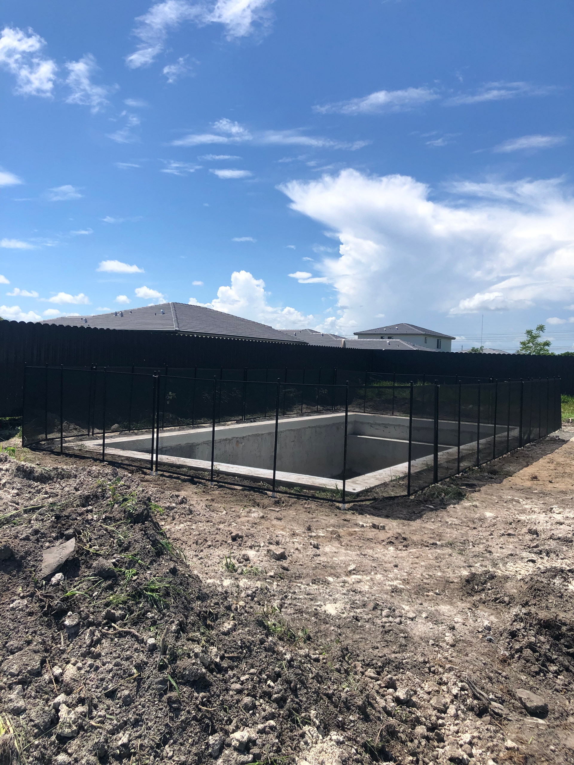a large swimming pool is surrounded by a black fence .