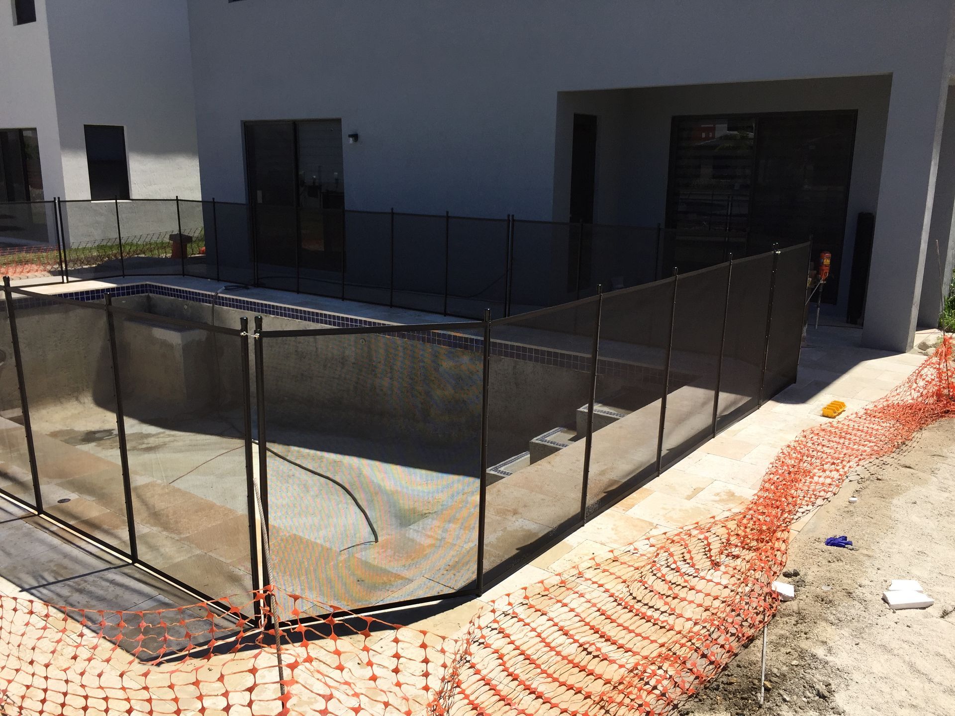 a fence around a swimming pool is being built in front of a house .