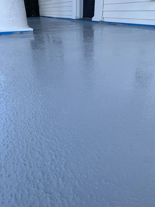 Blue-painted concrete floor between white walls, with a wet, textured surface and reflections at the top.