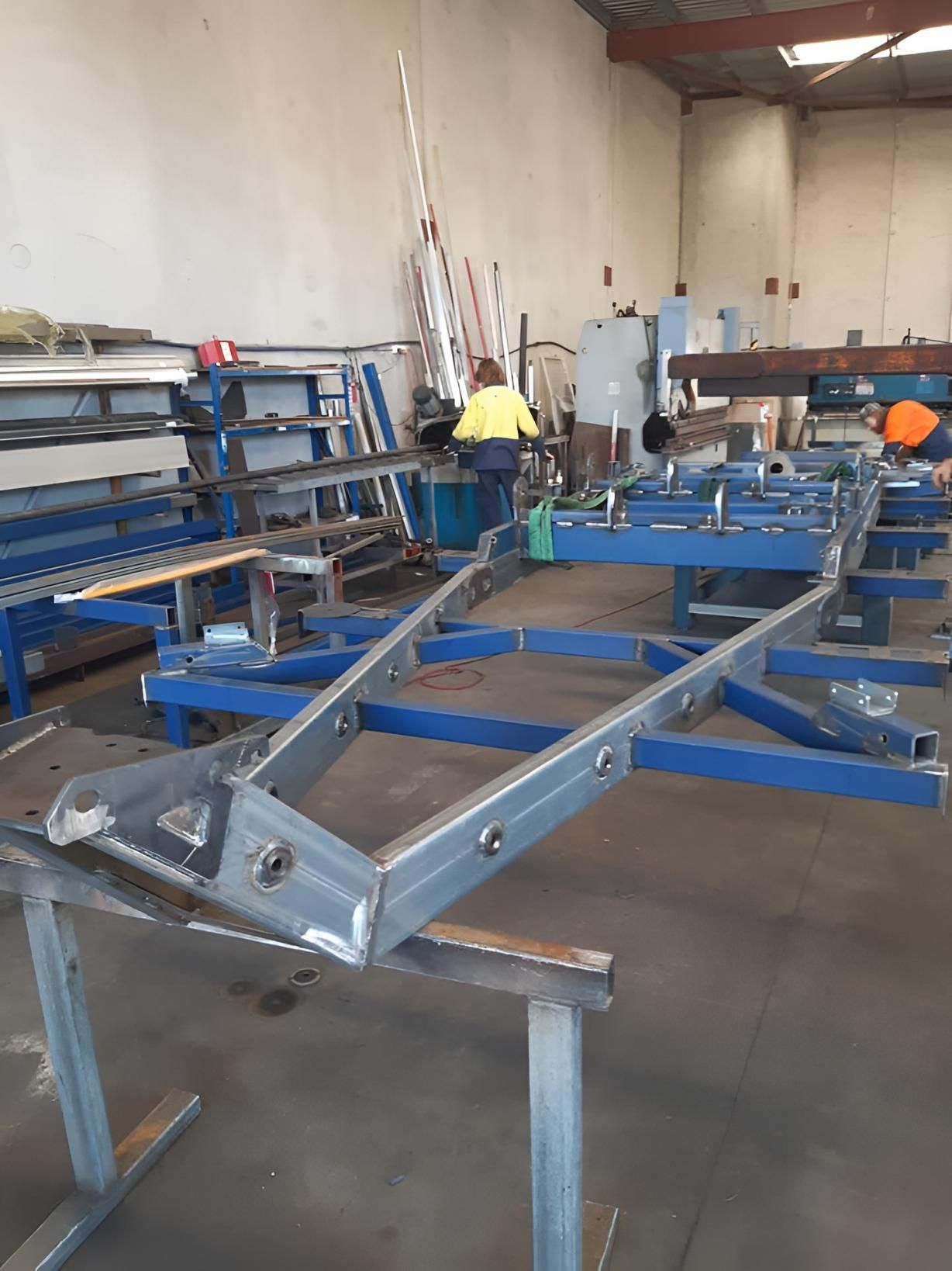 A Man is Working on a Metal Frame in a Factory — Turnweld Engineering in Coolum Beach, QLD