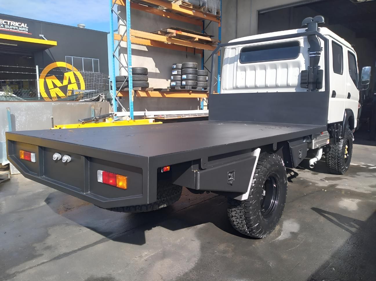 A White Truck With a Flat Bed is Parked in Front of a Building — Turnweld Engineering in Coolum Beach, QLD