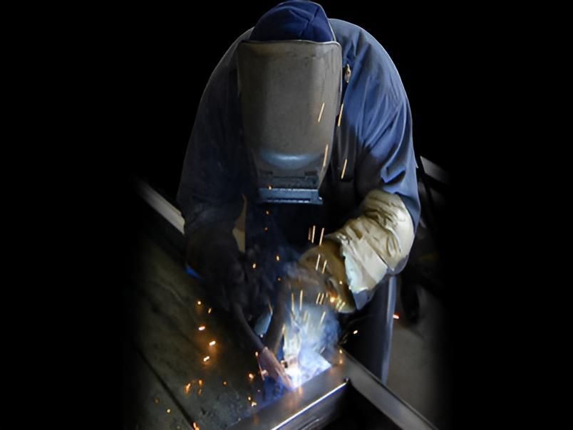 A Man Wearing a Welding Mask is Welding a Piece of Metal — Turnweld Engineering in Coolum Beach, QLD