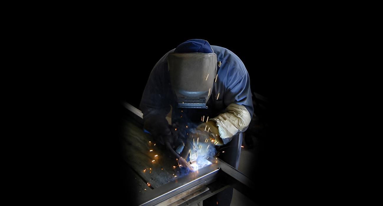 Man is Welding a Piece of Metal in a Dark Room — Turnweld Engineering in Coolum Beach, QLD