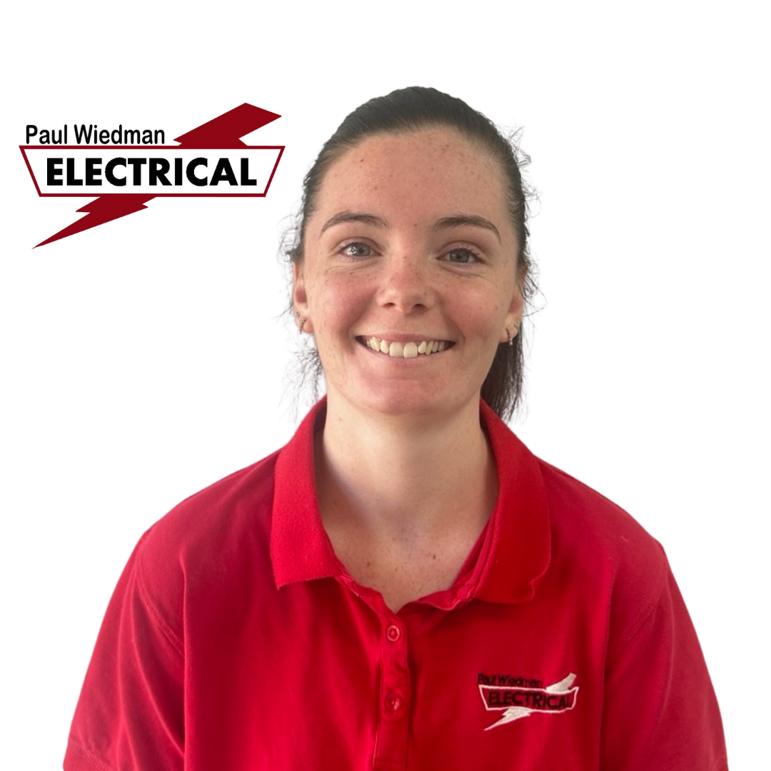 Woman in red polo shirt smiles at the camera, with the 