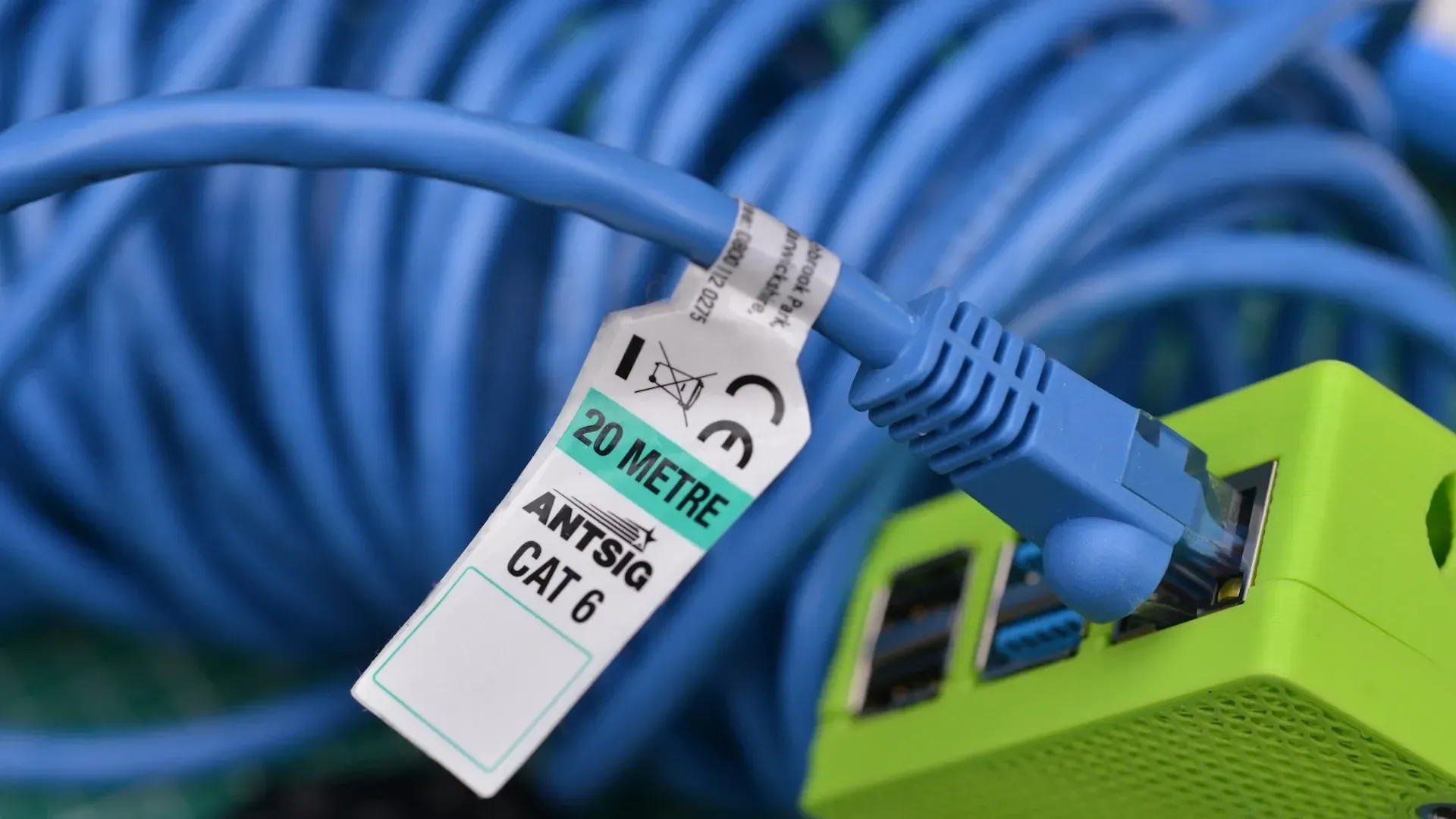 Blue Ethernet cable connected to a green device; the cable has a label indicating it is CAT 6, 20 meters. — Paul Wiedman Electrical in Harristown, QLD