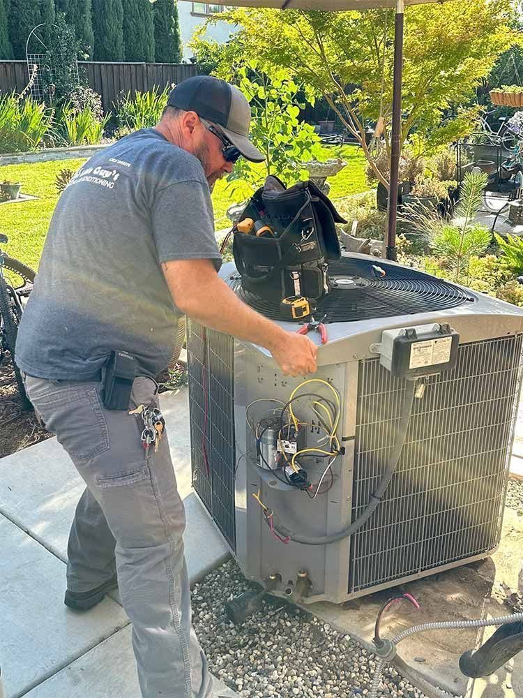 HVAC technician working on an air conditioning unit outside.