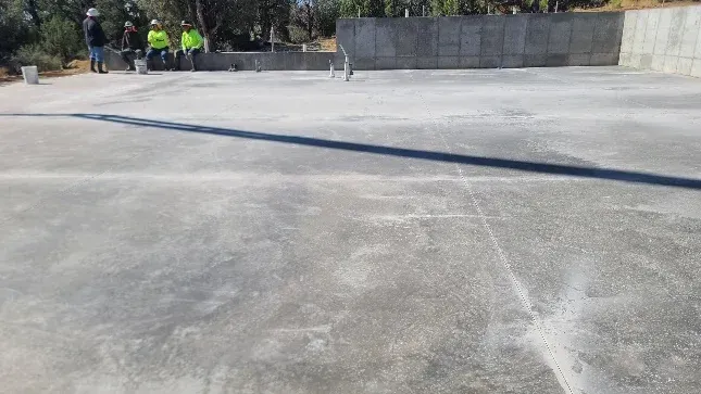 A group of people are standing on top of a concrete floor.