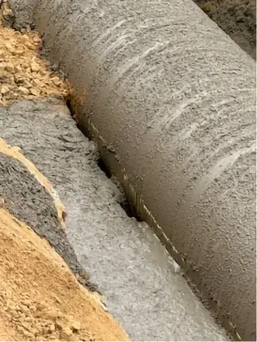 A close up of a concrete pipe being poured into the ground.