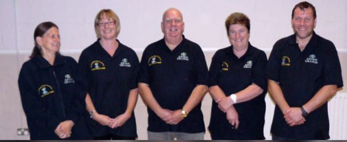 3 Counties Dog Training Team Members in a row wearing  branded black tops