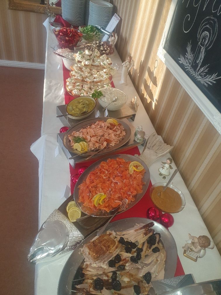 A long table topped with plates of food and a chalkboard.
