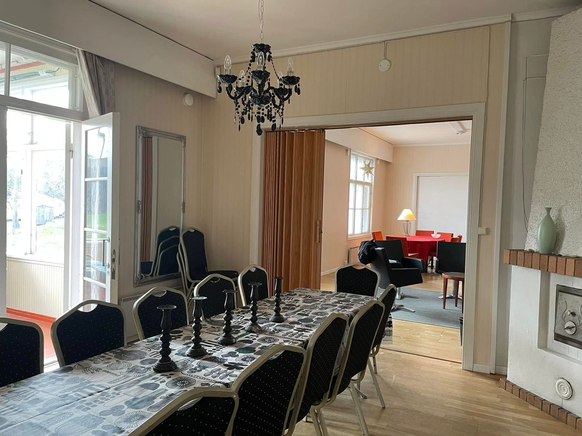 A dining room with a long table and chairs and a chandelier.