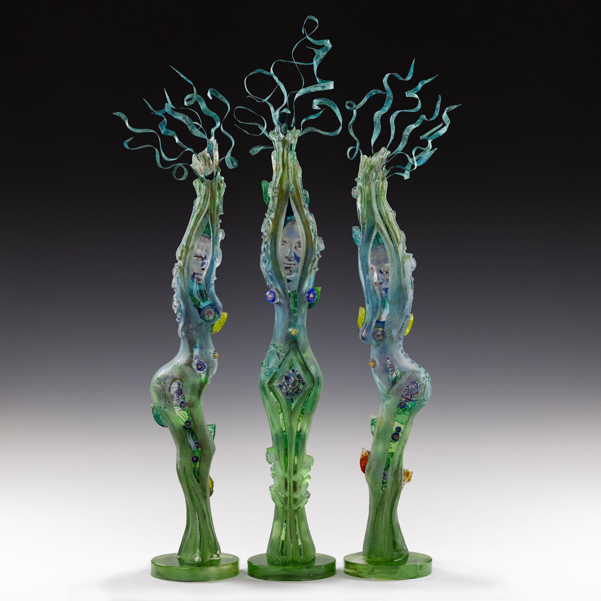 Three sculptures of a woman are standing next to each other